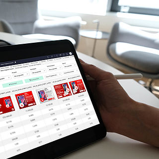 Frau sieht sich Analytics-Daten von verschiedenen Werbemitteln auf einem Tablet an.