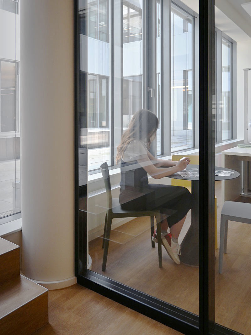 Mitarbeiterin sitzt in modernen, hellem Loft-Office in einer Sitzecke