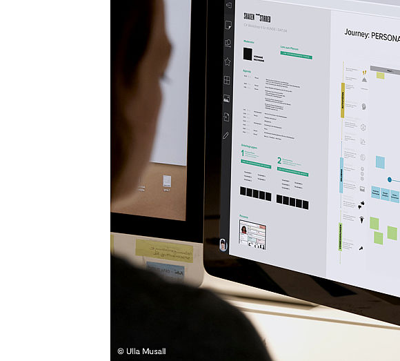 Workshopteilnehmerin sieht sich digitales Workshopboard an